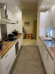 a kitchen with white cabinets and a sink at Chichester Luxury One Bed Apartment in Chichester