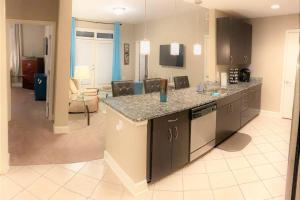 a kitchen with a counter and a living room at Midtown Quarters- Spacious 2bd 2ba, Private Balcony -S55 in Atlanta