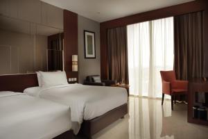 Uma cama ou camas num quarto em The Luxton Cirebon Hotel and Convention