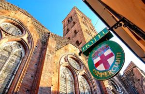 a large brick building with a sign in front of it at Art Hotel Commercianti in Bologna