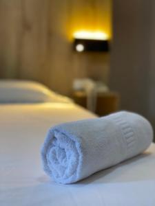 a white towel sitting on top of a bed at Hotel Wampushkar in Zamora