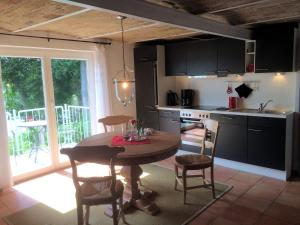 a kitchen with a wooden table and chairs and a kitchen with a window at Ferienhaus direkt am Schmalensee in Schmalensee