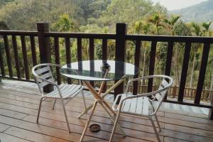 a glass table and two chairs on a deck at FU Xuan Villa in Sanyi