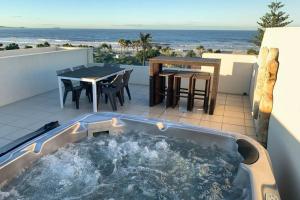 a hot tub on a patio with a table and chairs at 338 Paradiso Kingscliff Beach in Kingscliff