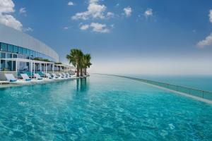 a large swimming pool next to a building with palm trees at Address Beach Resort in Dubai