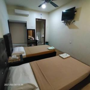 a room with two beds and a flat screen tv at BINKHALED HOTEL in Kota Tinggi