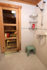 a bathroom with a shower and a green stool at Ounasloma Luxury Cottages in Enontekiö
