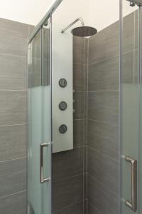 una doccia con porta in vetro in bagno di Appartamento Sestante a Lido di Ostia