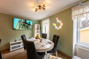 - une salle à manger avec une table, des chaises et une télévision dans l'établissement Magnolia Central Apartment #1, à Sighişoara