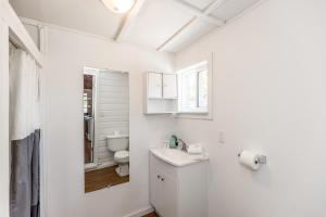 a white bathroom with a toilet and a sink at Beachside Summer Cabins in Wasaga Beach +26 photos