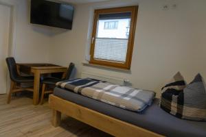 a room with a bed and a table and a window at Gästehaus Familie John in Veitsbronn