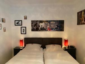 two beds in a bedroom with two lamps and pictures on the wall at Hotel Niedersachsen in Quakenbrück