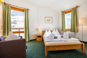 pokój hotelowy z dwoma łóżkami i kanapą w obiekcie Hotel Das Gastein - ganzjährig inklusive Alpentherme Gastein & Sommersaison inklusive Gasteiner Bergbahnen w mieście Bad Hofgastein
