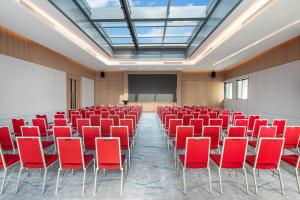 a conference room with red chairs and a screen at Holiday Inn Shanghai Nanjing Road by IHG in Shanghai