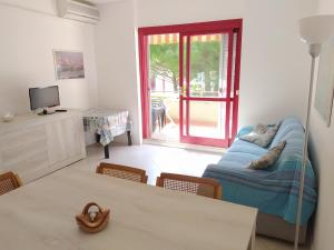 Una sala de estar con una cama y una mesa con sillas. en Bilocale in Residence con Piscina", en Marina di Bibbona