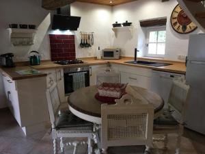 uma cozinha com uma mesa com cadeiras e um fogão em La Tuilerie Grange (Adults only gite) with two en-suite double bedrooms em Le Bugue