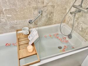 a bathroom with a bath tub with a glass door at MonCoeur, maison et jardin à 700 m des Hospices de Beaune in Beaune