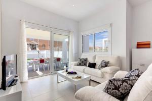 una sala de estar con un sofá y una mesa en Villa Atalis by Villa Plus, en Alaior