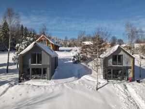 un par de edificios en la nieve en 3 WYMIARY, en Cisna