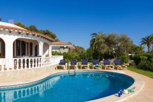 a swimming pool with chairs and a house at Villa Lavanda by Villa Plus in Santo Tomás