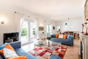聖托馬斯的住宿－Villa Leona by Villa Plus，客厅配有蓝色的沙发和玻璃桌