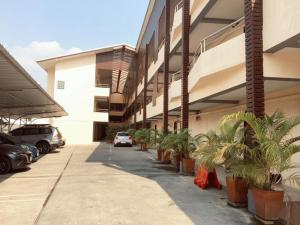 a parking lot with potted plants next to a building at Pangviman Residence in Ban Prong Phra Bat Nok (1)