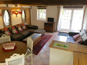 a living room with a couch and a table at La Tuilerie Grange (Adults only gite) with two en-suite double bedrooms in Le Bugue