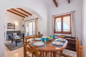 Un comedor con mesa y sillas y una sala de estar. en Villa San Jose by Villa Plus, en Cala'n Porter