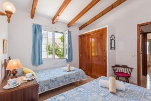 Un dormitorio con dos camas y una ventana. en Villa San Jose by Villa Plus, en Cala'n Porter
