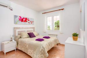 a bedroom with a bed with purple pillows on it at Villa Xaloc Blanes by Villa Plus in Cala Blanca +18 photos