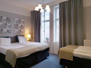 a hotel room with two beds and a window at Crystal Plaza Hotel in Stockholm
