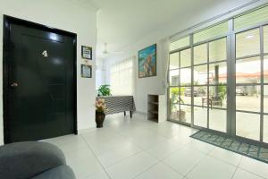 a hallway with a black door in a building at OYO Home 90230 Dh Residence in Kota Belud