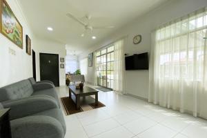 ein Wohnzimmer mit einem Sofa und einem TV in der Unterkunft OYO Home 90230 Dh Residence in Kota Belud