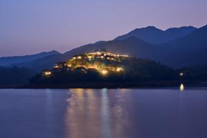 a house on an island in the water at night at MOUNTAIN SHADOWS RESORTS in Wayanad