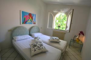 a bedroom with two beds and a window at Lignano Pineta exclusiv in Lignano Sabbiadoro