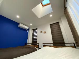 a bedroom with two beds and a blue wall at Wonderful stay TOKYO nakanoshinbashi in Tokyo