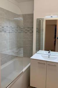 La salle de bains est pourvue d'une baignoire, d'un lavabo et d'une douche. dans l'établissement Goélia Les Chalets des Pistes, à Combloux
