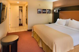 a hotel room with a large bed and a stool at GreenTree Hotel Phoenix West in Phoenix