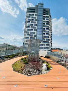 un edificio alto con un jardín de flores delante de él en New Luxury City centre apartment with panoramic view, free parking, en Bratislava