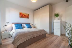 1 dormitorio con 1 cama grande con almohadas azules en Sea to Sky Apartments, en Venecia