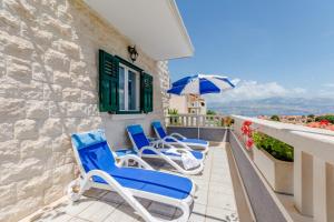 a group of chairs on a balcony with an umbrella at Villa Blue Oasis in Postira