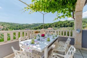 a white table and chairs on a balcony with a view at Villa Blue Oasis in Postira +23 photos