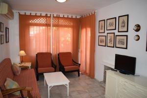 sala de estar con 2 sillas y TV en Verano Azul 75, en Nerja