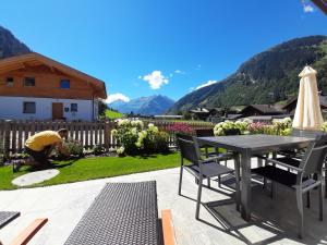 a man working in a yard with a table and chairs at Hochalmbahnen Chalets Rauris 1-04, Maislaufeldweg 1d in Rauris