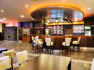 restauracja z barem z białymi krzesłami i stołami w obiekcie Hotel Aquarius Restaurant Wellness Spa w Ciechocinku