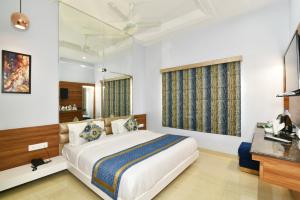 a bedroom with a large bed and a mirror at Hotel Vacation Inn in Amritsar