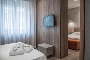 um quarto de hotel com uma cama e uma televisão na parede em AmbientHotels Panoramic em Rimini