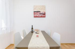 - une table à manger avec des chaises blanches et une bouteille de coke dans l'établissement Apartment in Stari Grad (Hvar) with Balcony, Air condition, WIFI, Dishwasher (3695-1), à Stari Grad