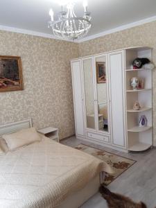 Guest House Pragma في بياتيغورسك: غرفة نوم بسرير وثريا