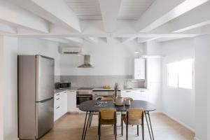uma cozinha com uma mesa com cadeiras e um frigorífico em Aspasios Calle Mayor Apartments em Madri